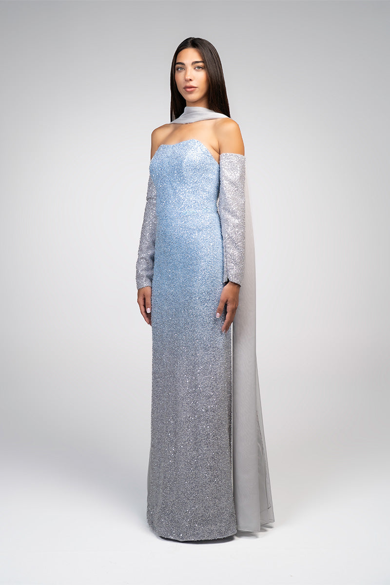 Baby blue to silver ombré embroidered gown by Joanna Andraos, featuring intricate embroidery and flowing fabric.