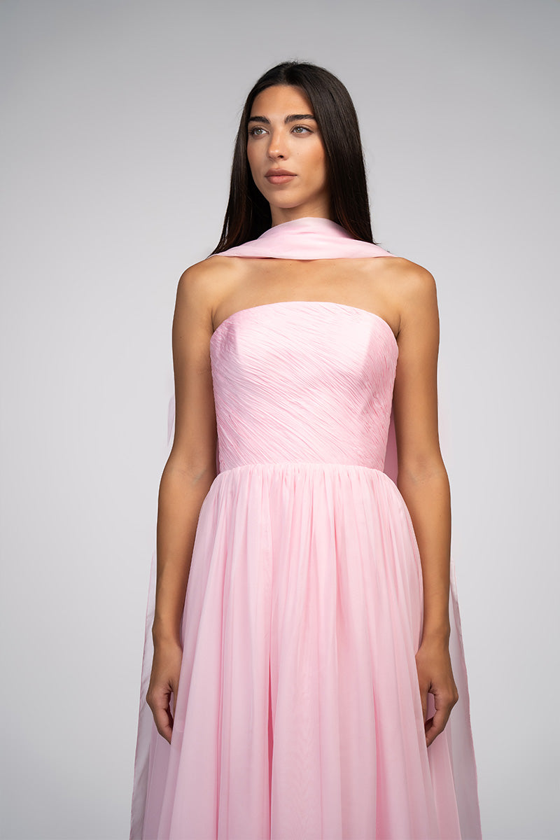 Elegant blush evening gown by Joanna Andraos, featuring flowing fabric and intricate detailing for formal occasions.