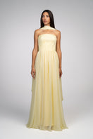 Yellow strapless gown by Joanna Andraos featuring a flowing silhouette and elegant design, shown from the front.