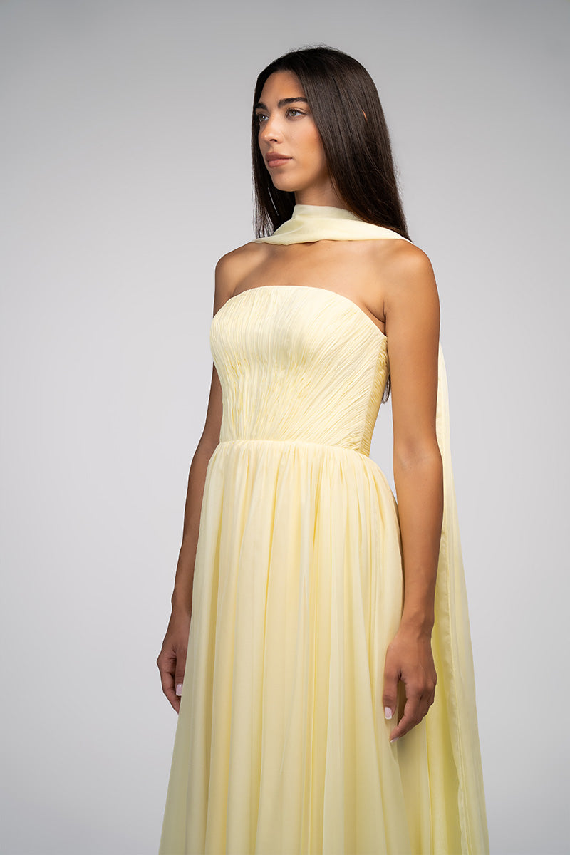 Yellow strapless gown by Joanna Andraos featuring a flowing silhouette and elegant design, shown on a model.