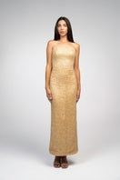 Gold embroidered gown by Joanna Andraos featuring intricate embroidery and flowing fabric, showcased on a model.