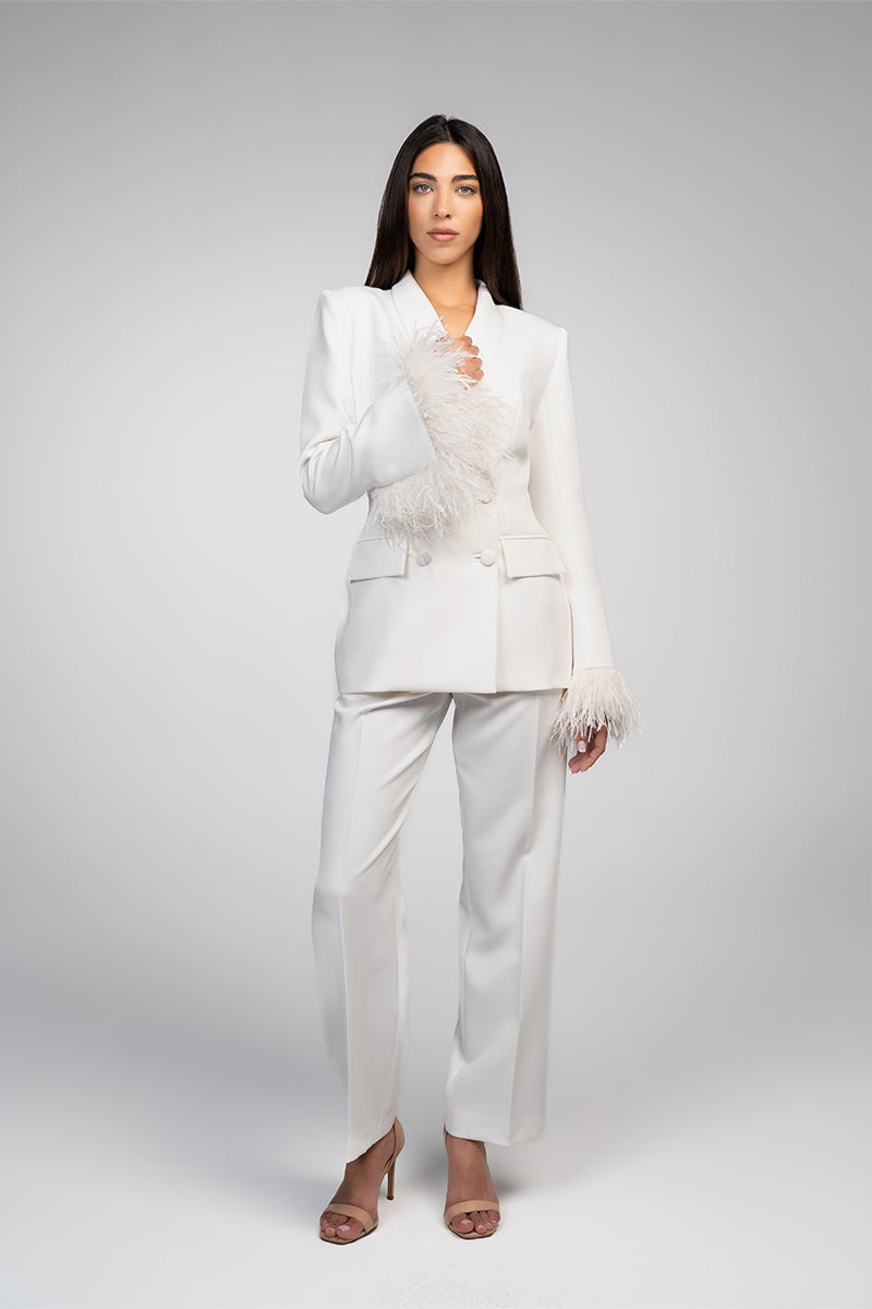 Ivory white hourglass suit set with feather details by Joanna Andraos, featuring a fitted silhouette and elegant design.
