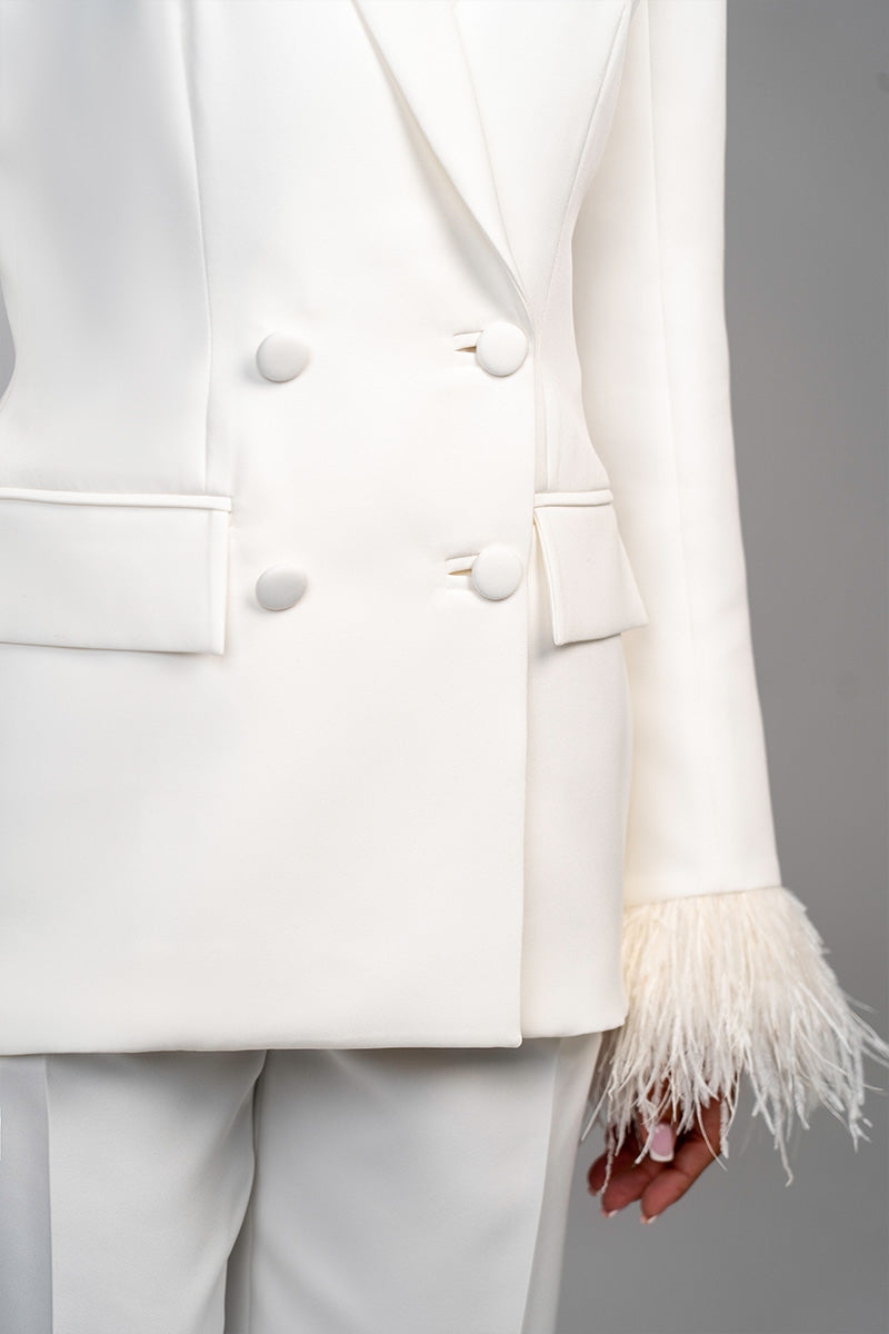 Ivory white hourglass suit set with feather details by Joanna Andraos, featuring a fitted silhouette and elegant design.