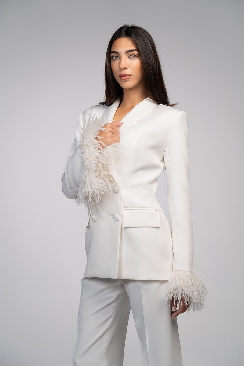 Ivory white hourglass suit with feather details by Joanna Andraos, featuring tailored fit and elegant feather accents.