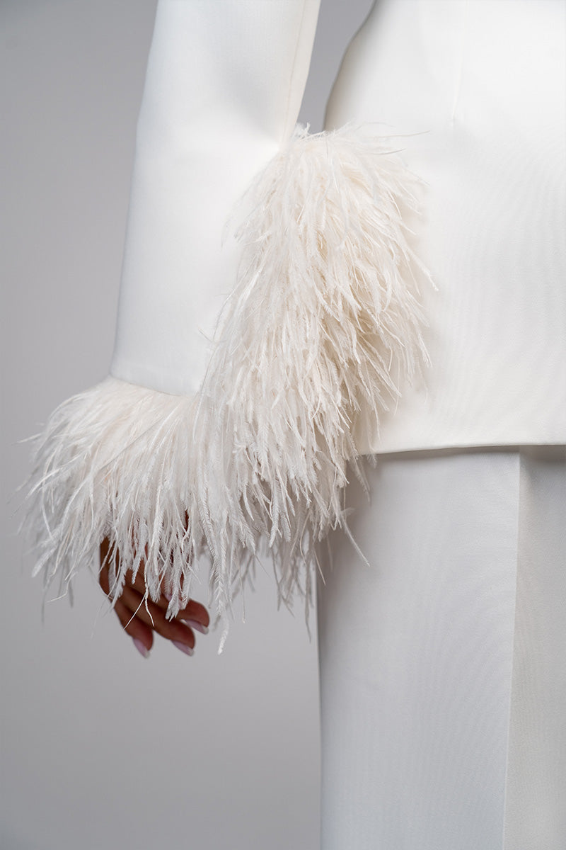 Ivory white hourglass suit with feather details by Joanna Andraos, featuring tailored fit and elegant feather accents.