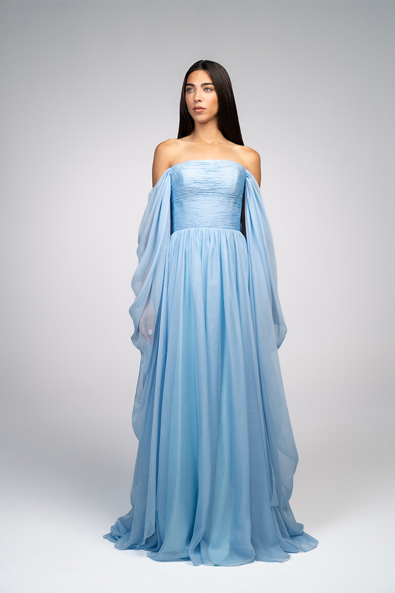 Elegant baby blue strapless gown by Joanna Andraos, featuring flowing fabric and a fitted bodice for formal occasions.