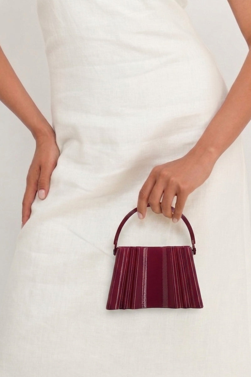 Touchless plum silk clutch bag with sleek design, featuring a smooth silk exterior and elegant style for evening occasions.