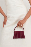 Touchless plum silk clutch bag with sleek design, featuring elegant craftsmanship and shiny silk fabric for stylish occasions.
