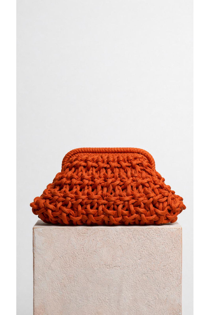 Small rust-colored rope clutch bag from Folklore The Label, featuring a minimalist design and compact size.