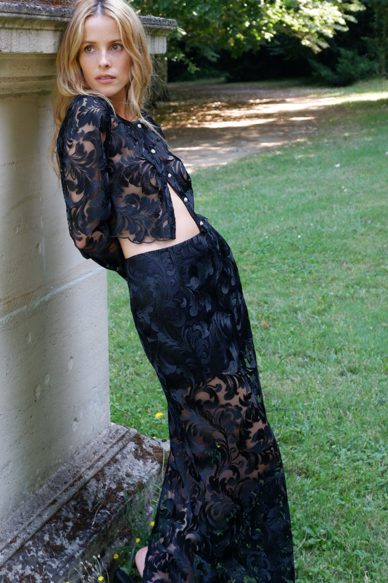 Black Scarlett Gasque Sovereign Maxi Skirt displayed in a campaign image, featuring a flowing design and elegant silhouette.