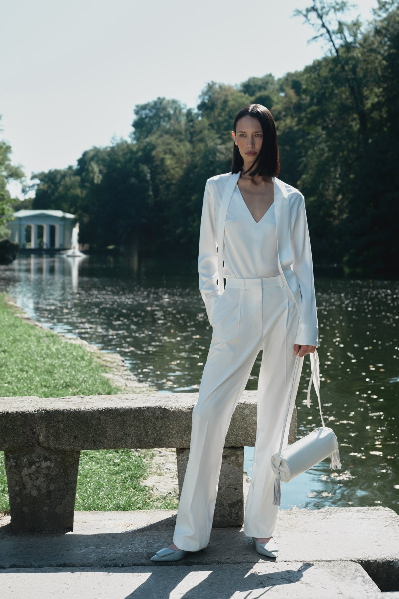 White PODYH YAPRAQ blouse, a stylish shirt with a relaxed fit and elegant design, shown on a hanger.