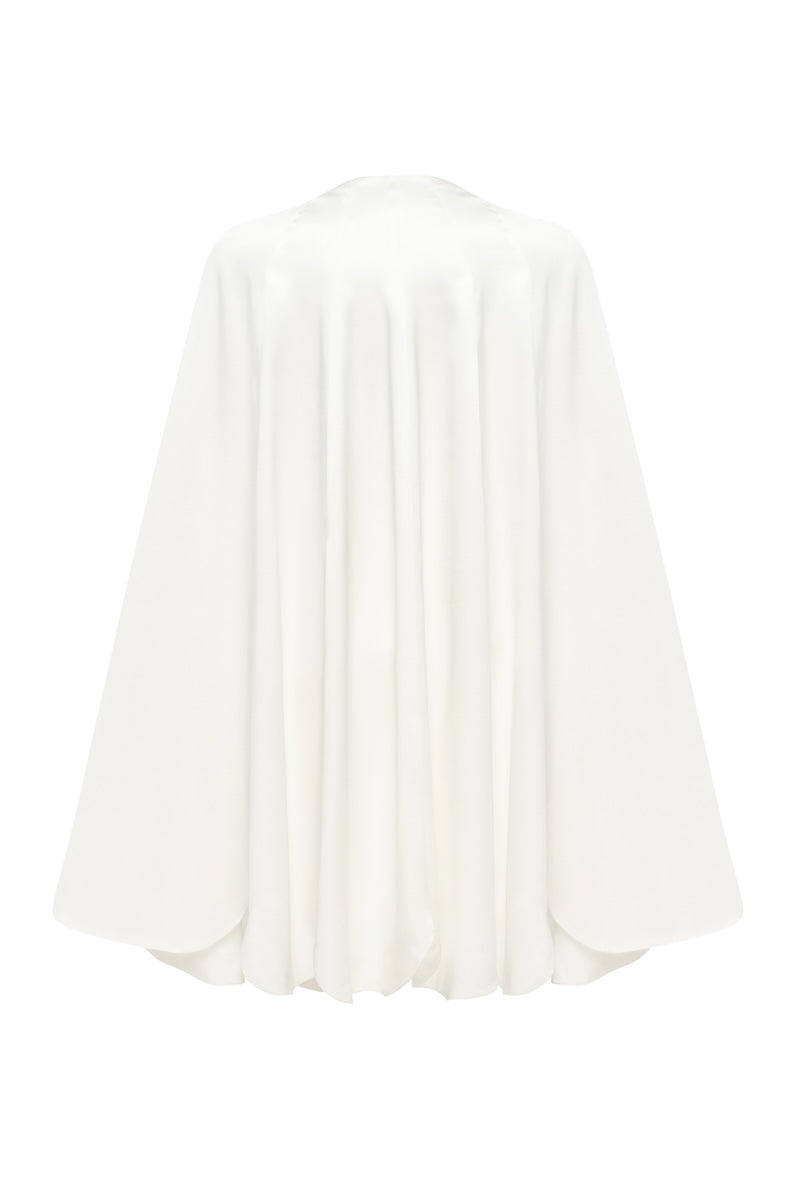 White PODYH GUL cape coat displayed on a hanger, showcasing its stylish design and fabric texture.