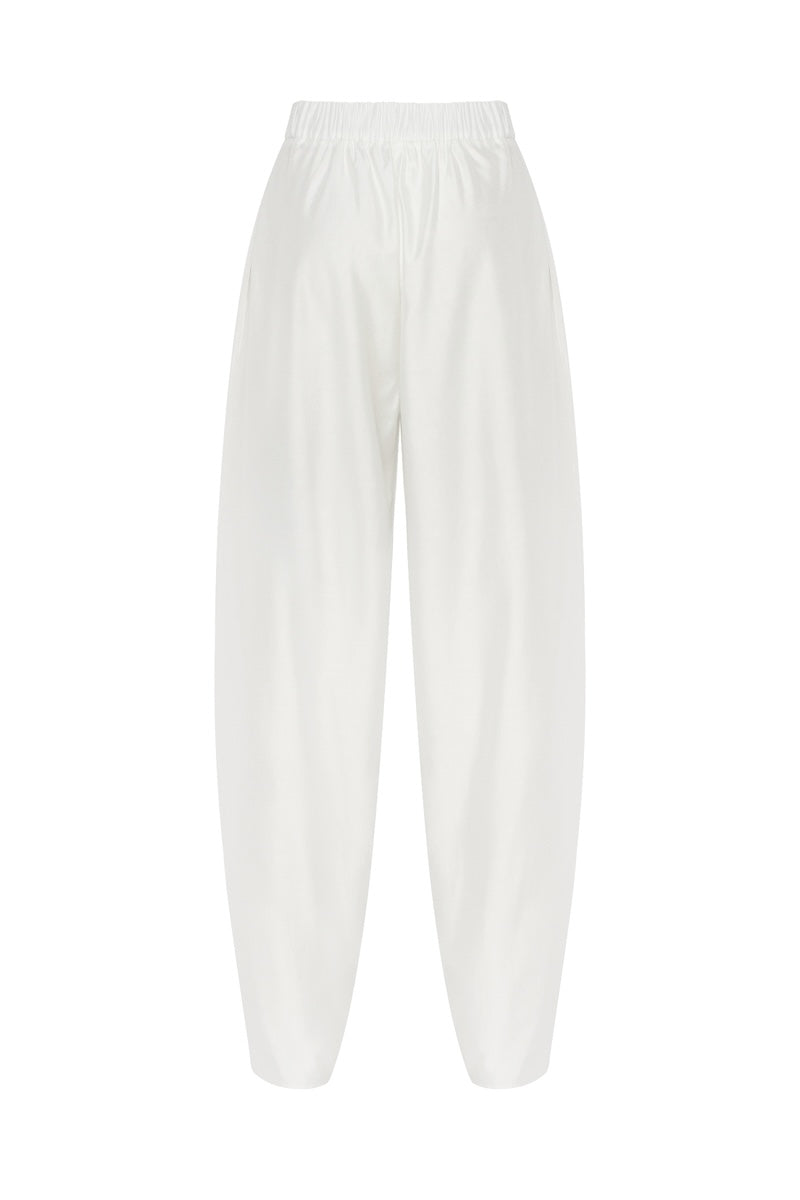 White Shalvar pants by PODYH, featuring traditional loose-fitting design with elastic waistband and intricate embroidery details.