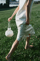 PODYH NAR clutch bag in eggshell color with sleek design and smooth finish, perfect for elegant evening accessories.