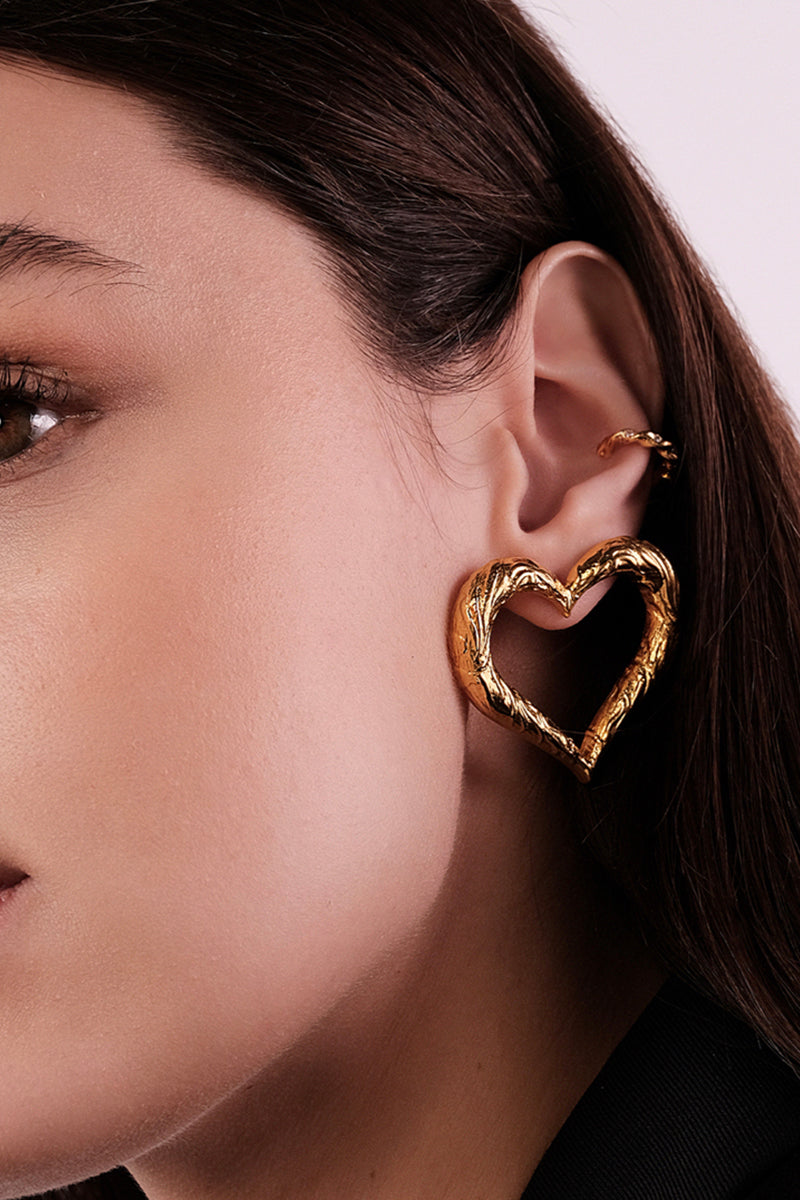 Heart-shaped earrings by Natia x Lako, featuring elegant jewelry design with shiny heart charms on sleek hooks.