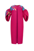 Hand-painted pink coat by Tiny Ink featuring abstract design, shown hanging on a display.