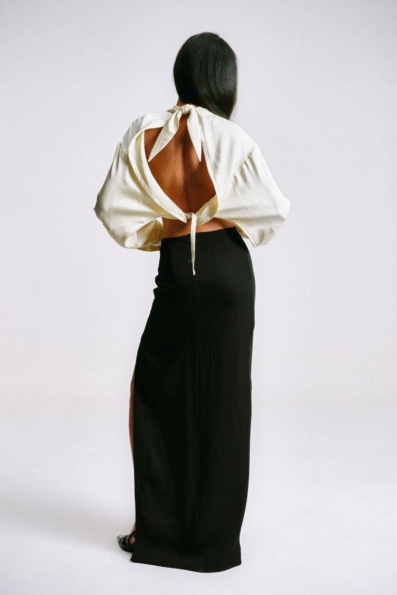 Black maxi skirt with cut-out slit and piercing details by Sean Sheila, shown from the back.