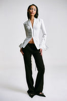 White kebaya shirt with corset detailing from Sean Sheila, featuring intricate embroidery and a fitted silhouette.