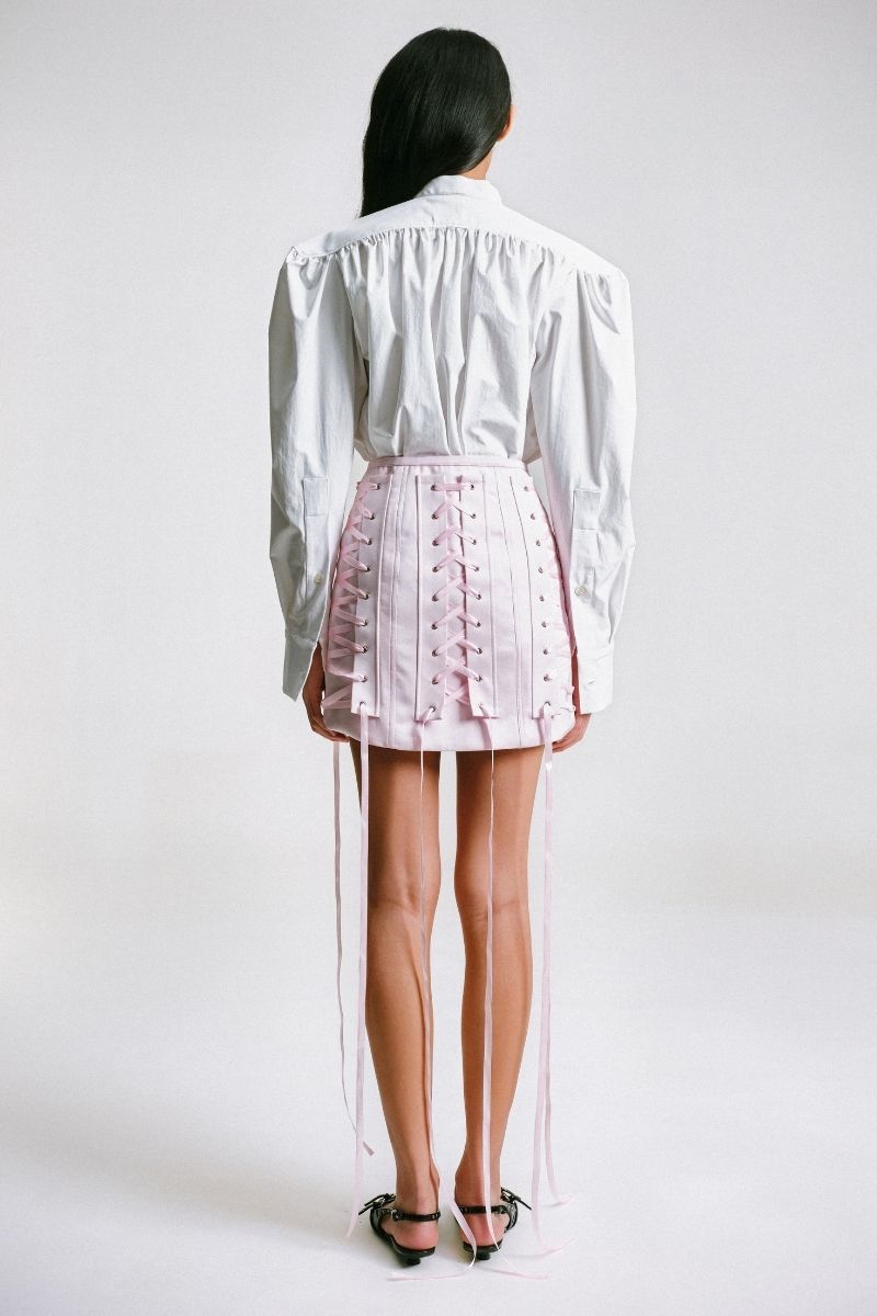 Pink Sean Sheila corseted mini skirt with fitted waist and front zipper, shown from the back view.