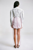 Back view of a pink corseted mini skirt from Sean Sheila, showcasing its fitted design and stylish detailing.