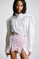 Pink corseted mini skirt by Sean Sheila, detailed close-up showing fitted waist and stylish design, perfect for trendy fashion looks.