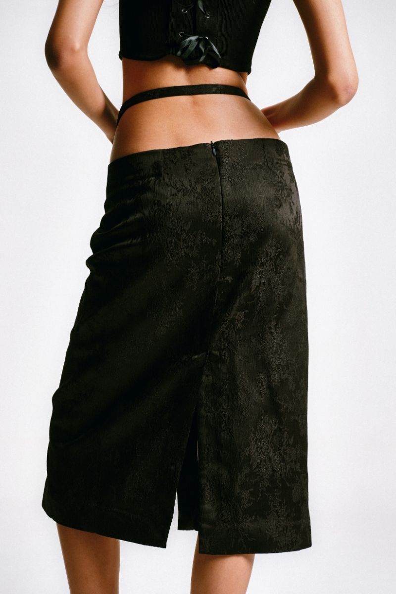 Black midi pencil skirt with stencil detail from Sean Sheila, shown from the back, featuring a sleek, fitted silhouette.
