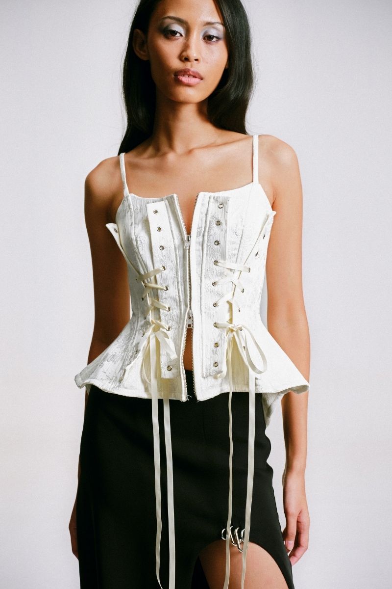 Close-up of Sean Sheila white deconstructed corset top, showcasing intricate design details and fabric texture.