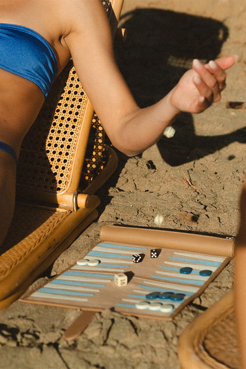 Travel backgammon board by Throwing Doubles featuring St. Barth design, with game pieces and dice on a wooden surface.