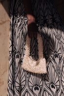 Cream and gold Nina top handle bag by Sac de Soul, stylishly displayed with elegant design and gold accents.