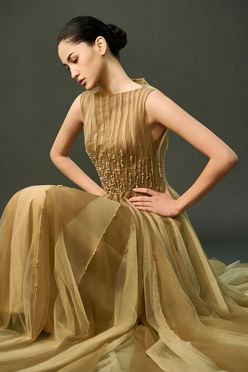 Light brown Noura gown by EEGEN STUDIO, elegant long dress with intricate design, displayed on a mannequin.