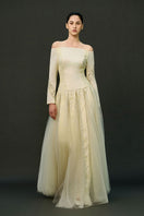 Off-white ELIRA gown by EEGEN STUDIO with elegant flowing fabric and intricate detailing, perfect for formal occasions.