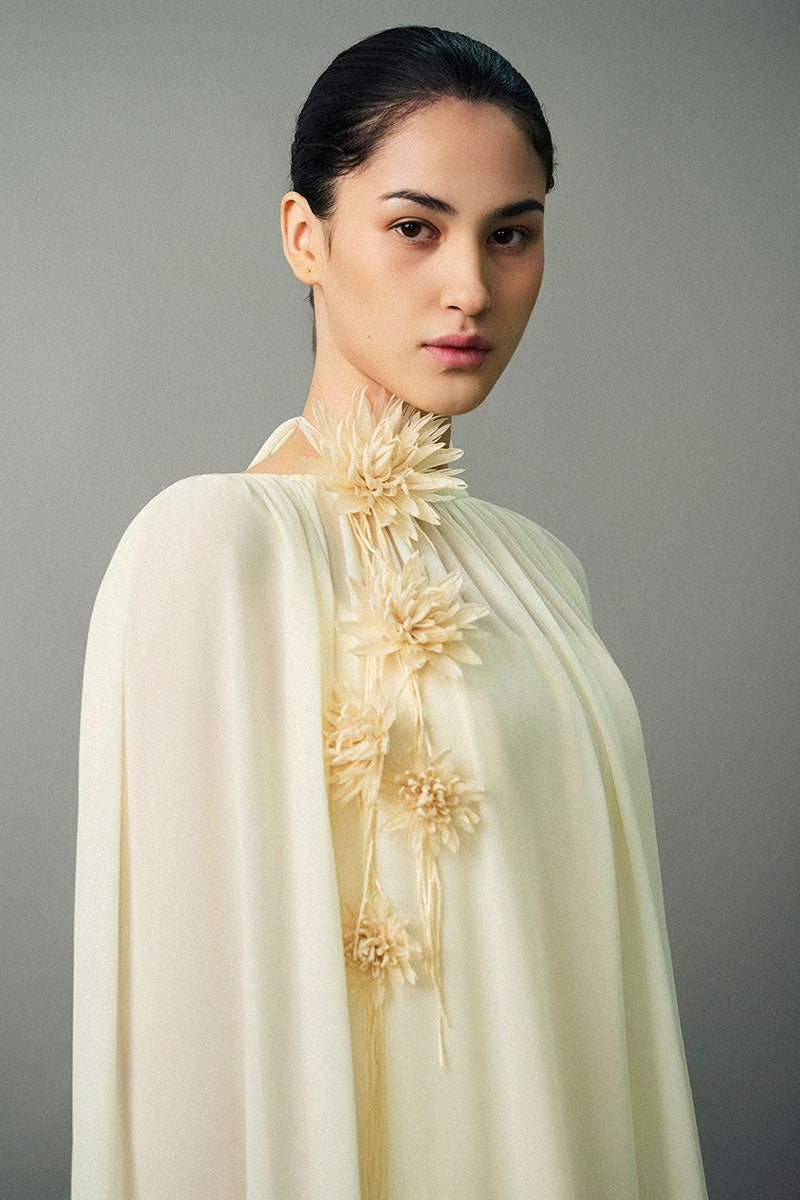 Off-white Nayla gown by EEGEN STUDIO, elegant formal dress with flowing fabric and intricate design, suitable for special occasions.