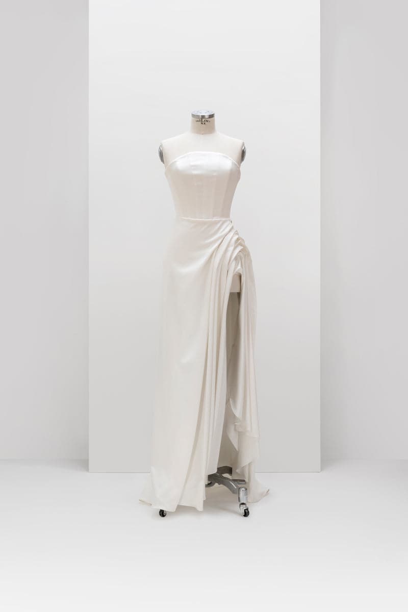 White sculptural corset gown by Monetre displayed on a mannequin, showcasing elegant design and intricate detailing.