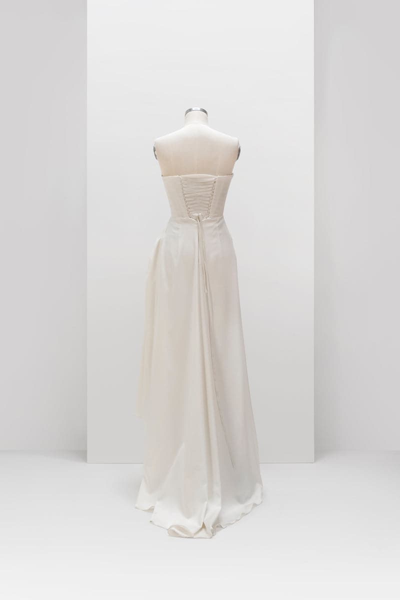 White sculptural corset gown by Monetre displayed on a mannequin, featuring intricate design and elegant silhouette.