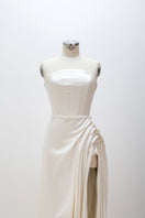 White sculptural corset gown by Monetre displayed on a mannequin, showcasing its intricate design and structured silhouette.