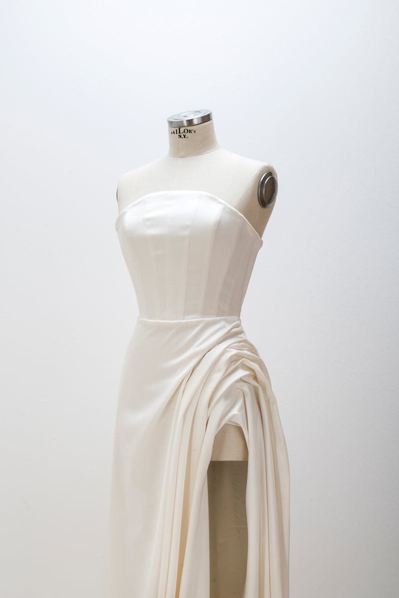 White sculptural corset gown by Monetre displayed on a mannequin, showcasing elegant structured design and intricate detailing.
