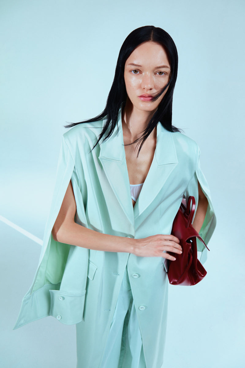 Light blue coat cape by Sayya, featuring a stylish and cozy outerwear design perfect for chilly days.