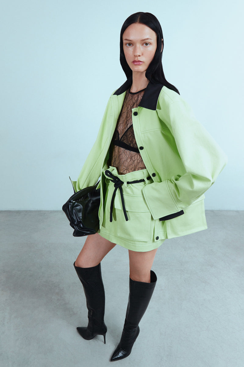 Green denim jacket by Sayya, casual jacket with front pockets and button closure, displayed on a hanger.