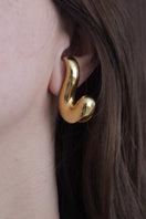 Gold sculpt earrings by Oz Objects featuring modern, abstract design with smooth, polished surfaces and artistic curves.