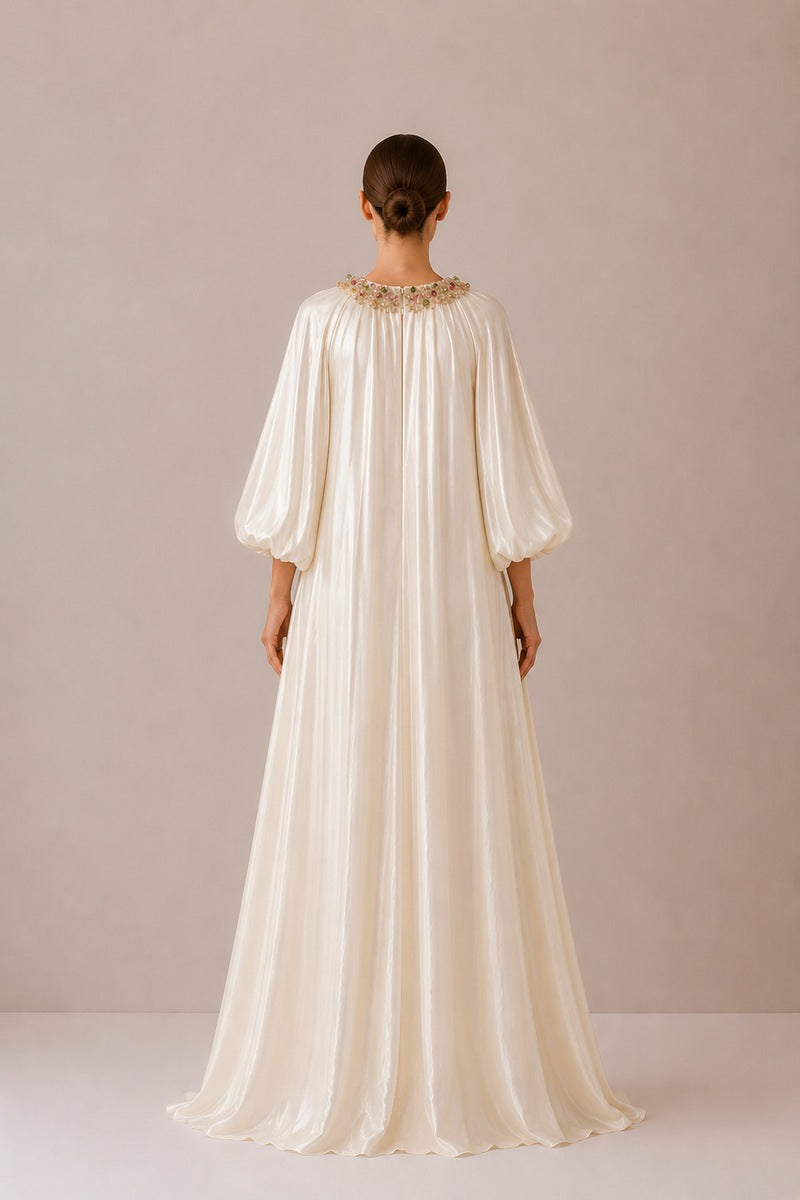 Nihan Peker Sedef dress in vanilla, elegant gown with flowing fabric and detailed design, shown on a model.