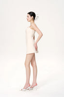 White Selena mini dress by Nana Jacqueline, styled on a model showcasing its elegant design and fit.