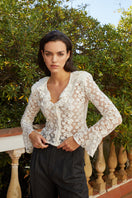 White Señorita Lucia blouse, a stylish women's shirt with a relaxed fit and elegant design, displayed on a hanger.