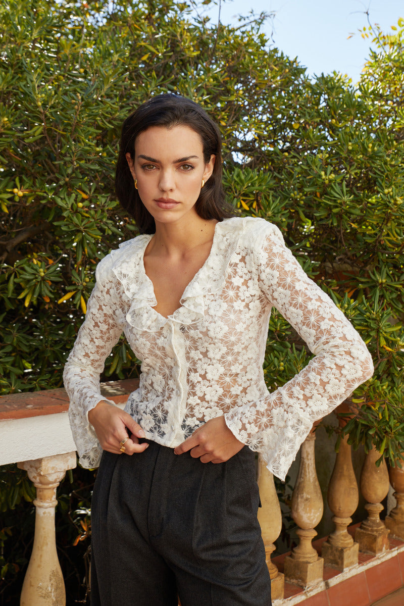 White Señorita Lucia blouse, a stylish women's shirt with a relaxed fit and elegant design, displayed on a hanger.