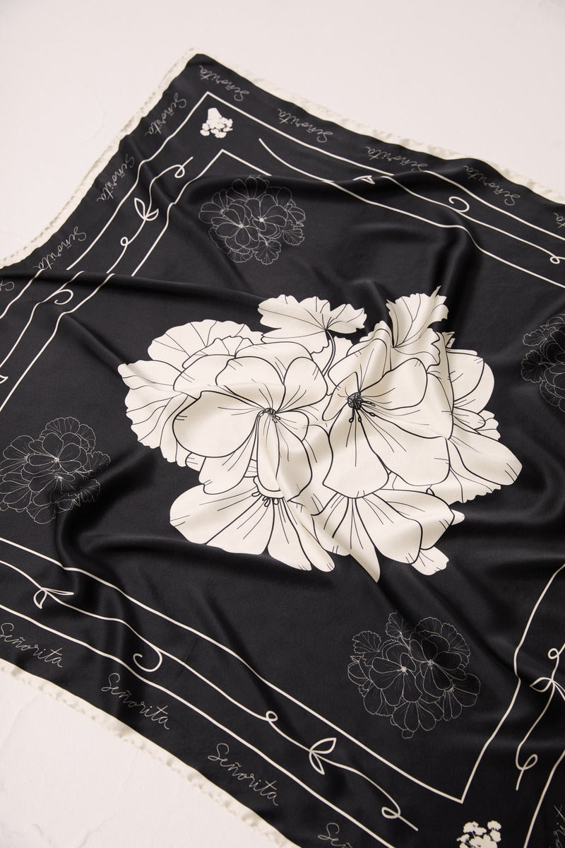 Black Señorita Luisa scarf displayed flat, showcasing its soft fabric and elegant design in a stylish accessory shot.