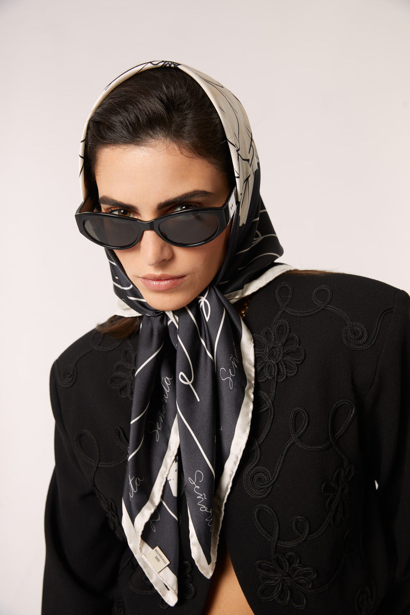 Black Señorita Luisa scarf made of soft fabric, styled as a versatile accessory in a fashion photo.