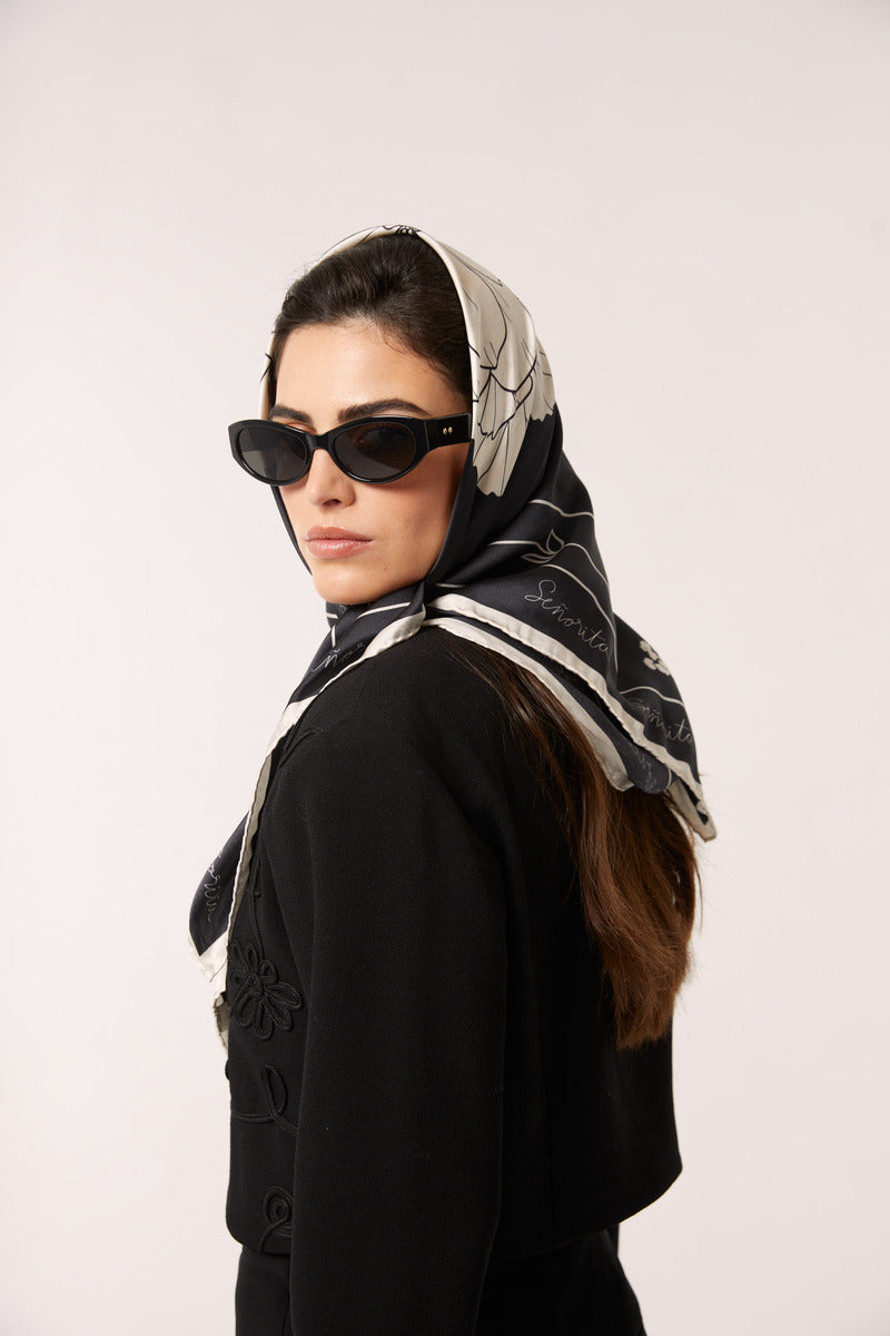 Black Señorita Luisa scarf with soft fabric, draped elegantly, showcasing its stylish design and versatile accessory for any outfit.