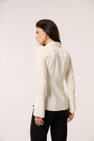 Ivory Alba blouse by Señorita, elegant shirt with a relaxed fit and detailed neckline, displayed on a hanger.