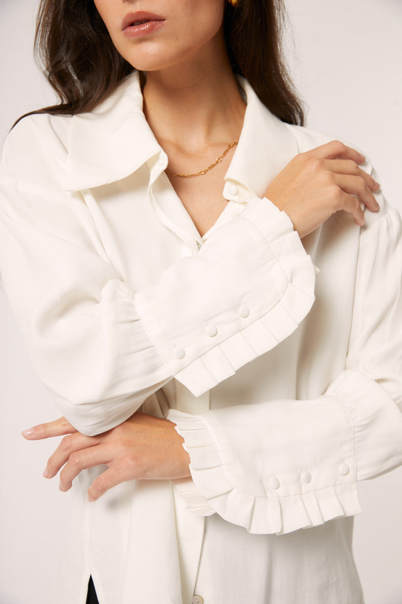 White Señorita Antonia blouse, a stylish shirt with a relaxed fit, displayed on a hanger against a neutral background.