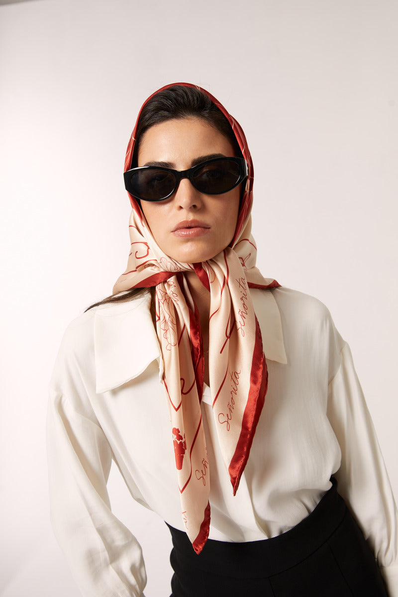 Red Señorita Luisa scarf draped over a neutral background, showcasing soft fabric and stylish design.