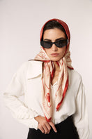 Red Señorita Luisa scarf displayed flat, showcasing its soft fabric and elegant design in a close-up shot.